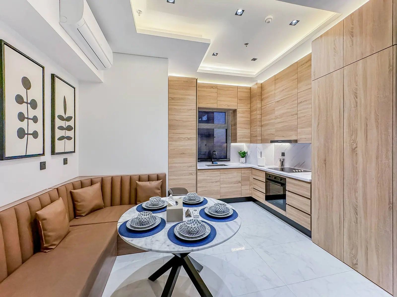 Kitchen with light wood cabinets and a dining nook with a leather banquette