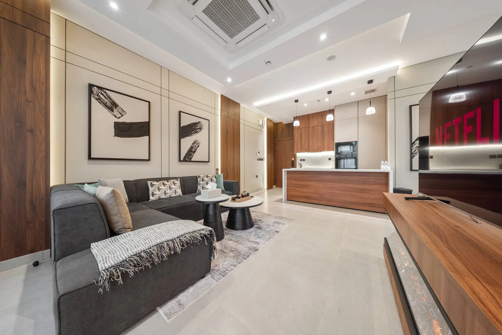 Living room seen from the windows, with the sofa, wood console and kitchen island beyond
