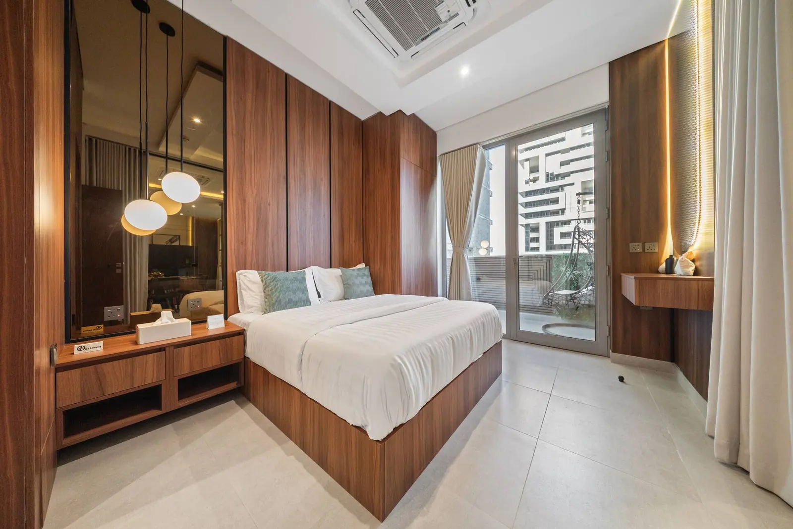 Master bedroom with walnut panelling, a king bed and a door onto the balcony