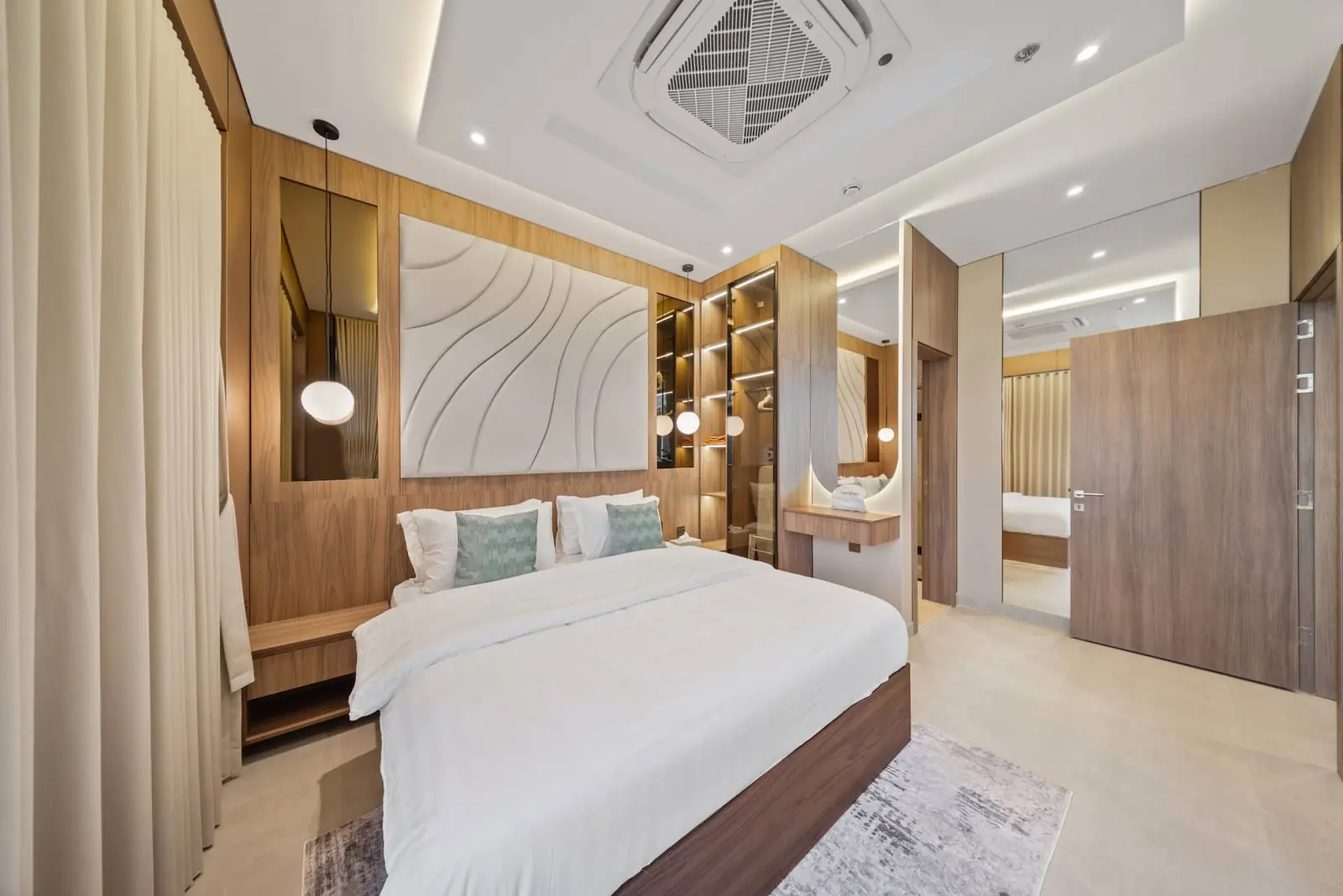 Master bedroom with a sculpted headboard, walnut wardrobes and a dressing area