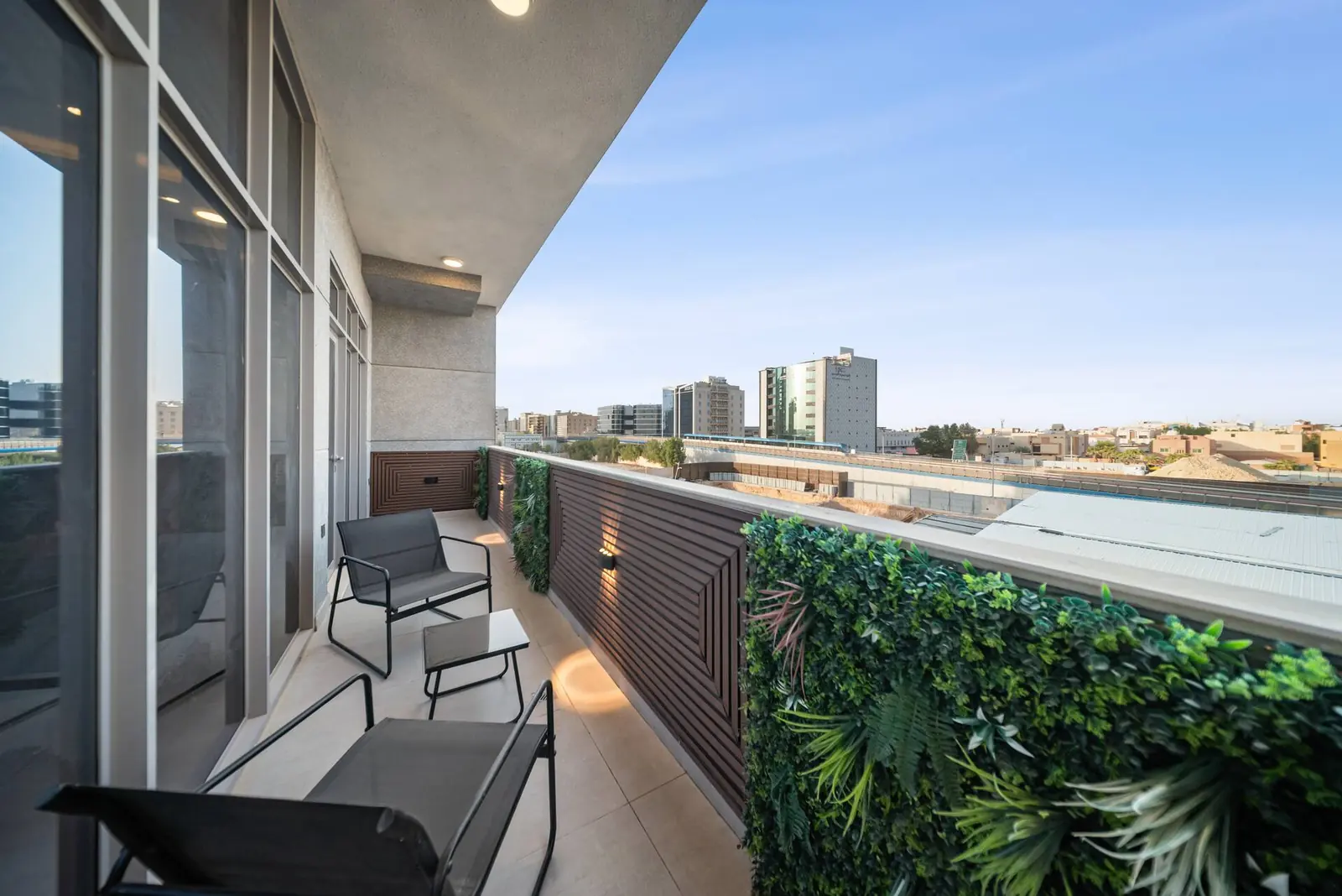 Balcony with chairs and a green wall, looking over the district