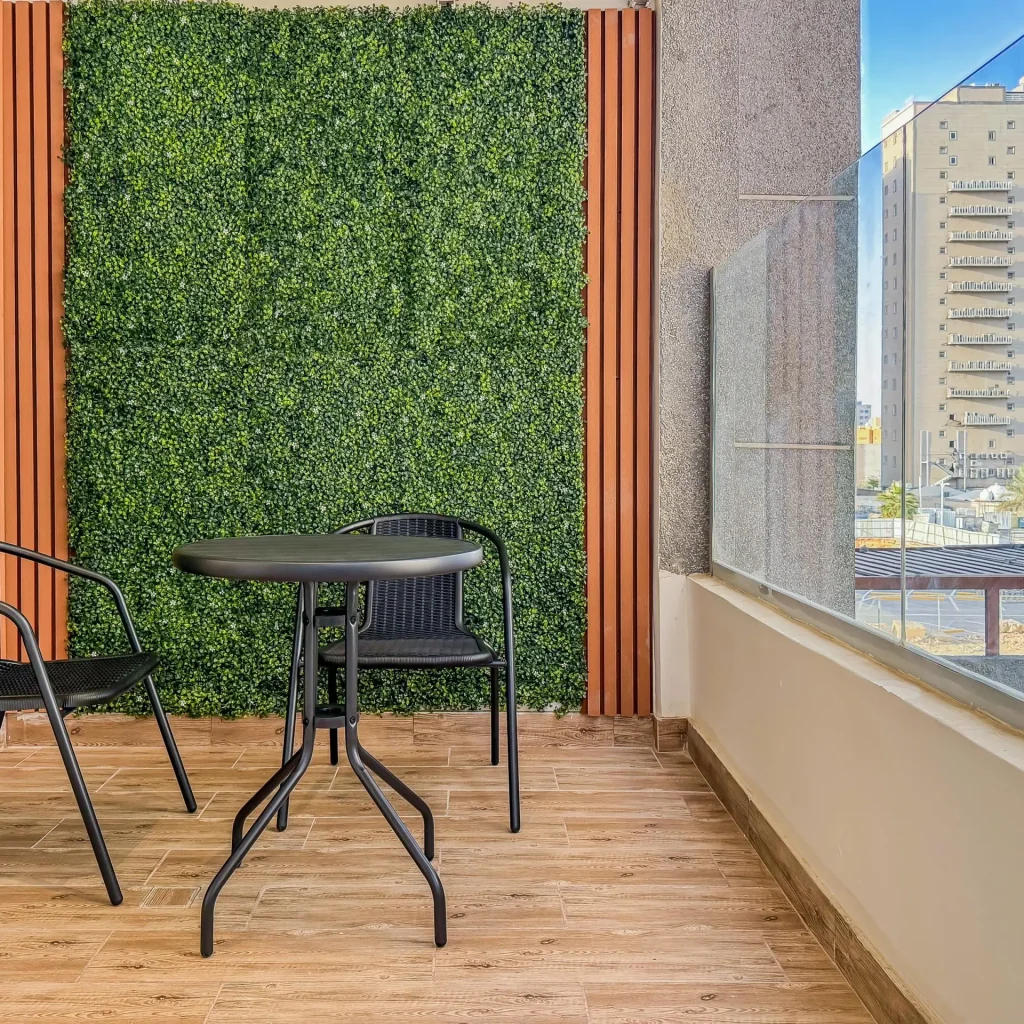 Private rear balcony with wicker seating and greenery wall, adding outdoor serenity to the high-floor furnished apartment with balcony.