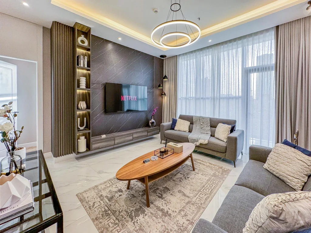 Stylish entertainment area of a corporate serviced apartment near KAFD in Riyadh, with sleek lighting, large windows, and smart TV setup perfect for relaxing or entertaining.