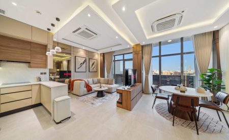 Bright, airy living room with full-height windows, balcony access, and a cozy modern fireplace.